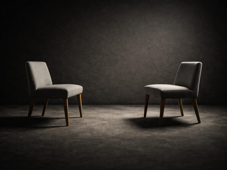 Two empty chairs facing each other with space between them symbolizing dialogue and boundaries in relationships.